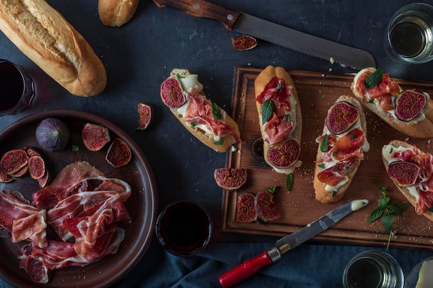 Sandwiches with cream cheese and jamon, close-up spanish appetizers with wine