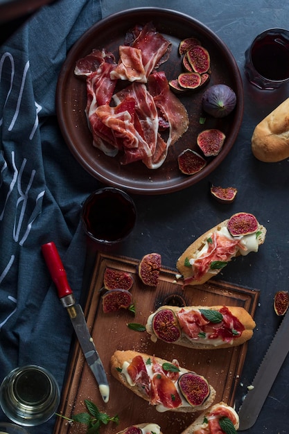 Sandwiches with cream cheese and jamon, close-up spanish appetizers with wine