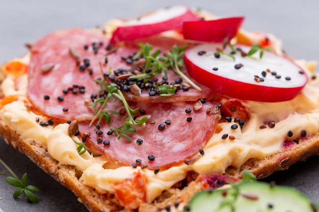 Sandwiches with cream cheese, vegetables and salami.