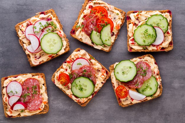 Sandwiches with cream cheese, vegetables and salami.