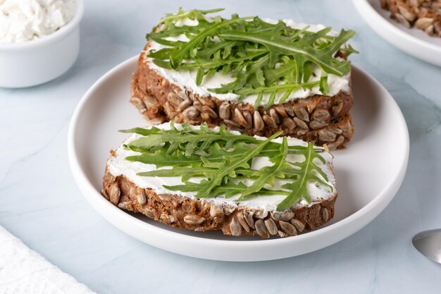 Sandwiches with curd cheese and arugula Rye bread with seeds
