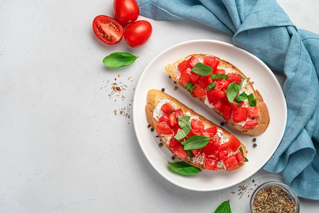 Sandwiches with fried toast, feta and tomatoes on a gray background. Italian bruschetta.