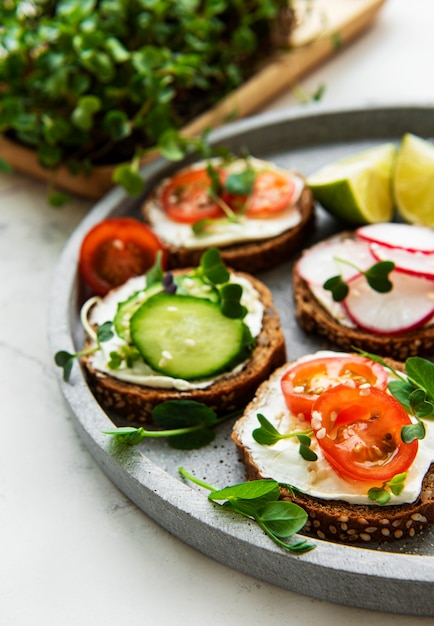 Sandwiches with healthy vegetables and micro greens on a white background