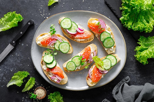 Sandwiches with homemade ciabatta bread salted salmon fish feta cheese cucumber onion and fresh lettuce salad