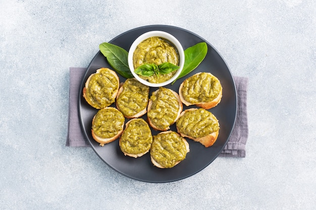 Sandwiches with pesto sauce, fresh basil leaves and garlic. A delicious healthy snack copy space