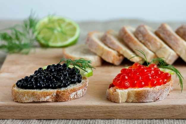 Sandwiches with red and black caviar with lime