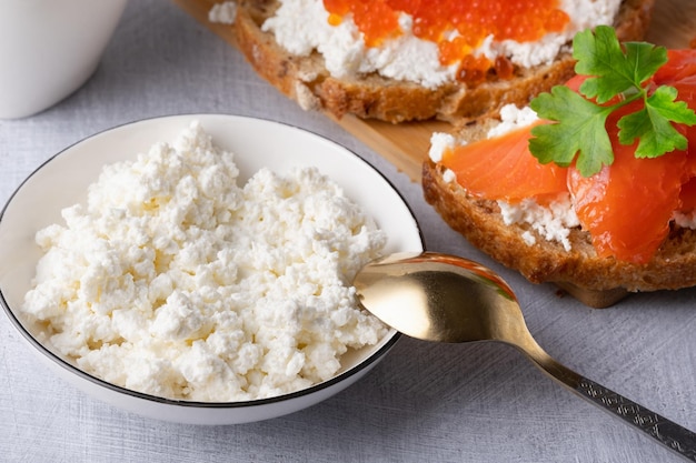 Sandwiches with red caviar cottage cheese and salted salmon Wooden cutting Board Close up