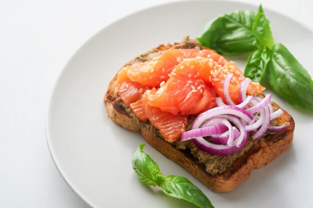 Sandwiches with salted salmon avocado guacamole red onions and basil Smorrebrod Set of danish open sandwiches Healthy food breakfast Clean eating dieting vegan food concept Top view