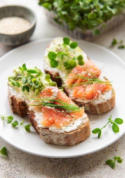 Sandwiches with salted salmon avocado and microgreens