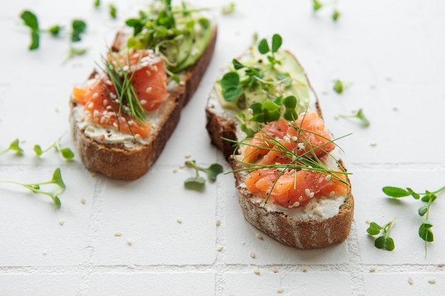 Sandwiches with salted salmon avocado and microgreens