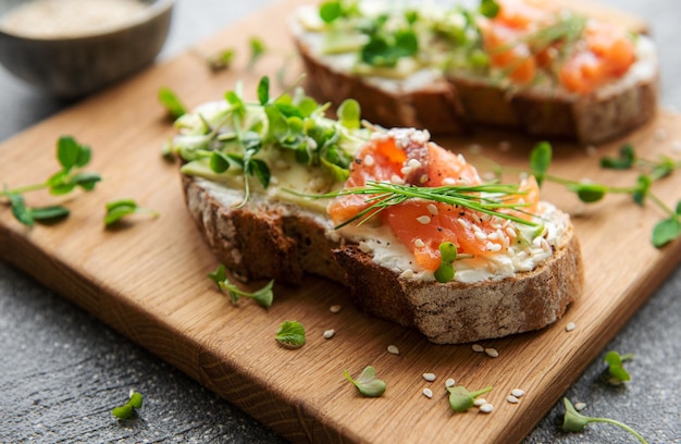 Sandwiches with salted salmon avocado and microgreens