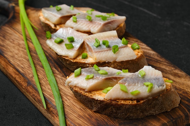 Sandwiches with salty herring and green onion