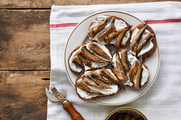 Sandwiches with sprats and mayonnaise on plate