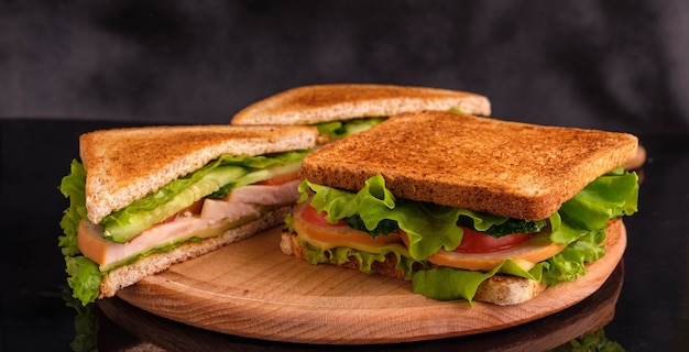 Sandwiches with tomatoes, cucumbers, ham and cheese