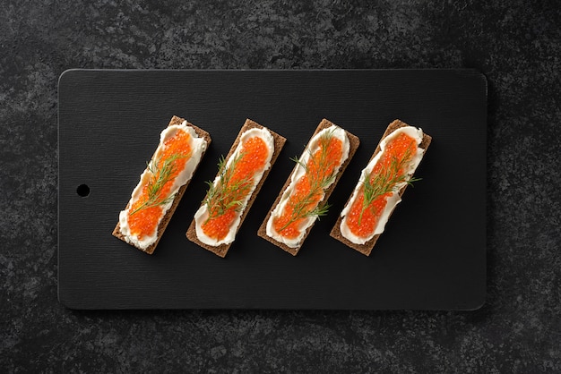 Sandwiches with trout caviar, curd cheese, dill, flat lay, keto diet.