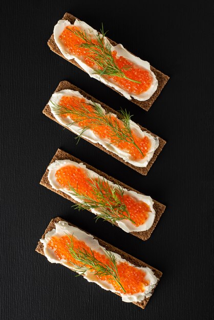 Sandwiches with trout caviar, curd cheese, dill, flat lay, keto diet.