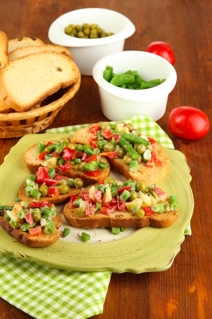 Sandwiches with vegetables and greens on plate on wooden table closeup