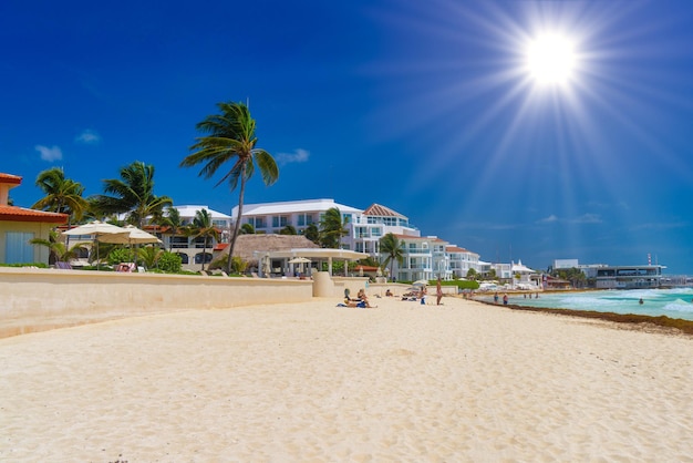 Фото Песчаный пляж в солнечный день с отелями в плайя-дель-кармен, мексика