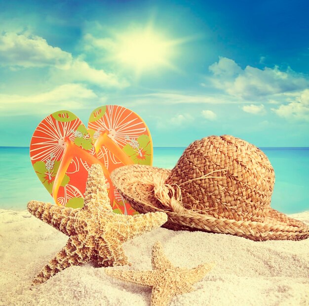 Photo sandy beach straw hat and starfish in summer