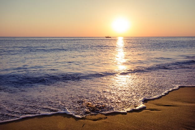 Foto spiaggia di sabbia al tramonto