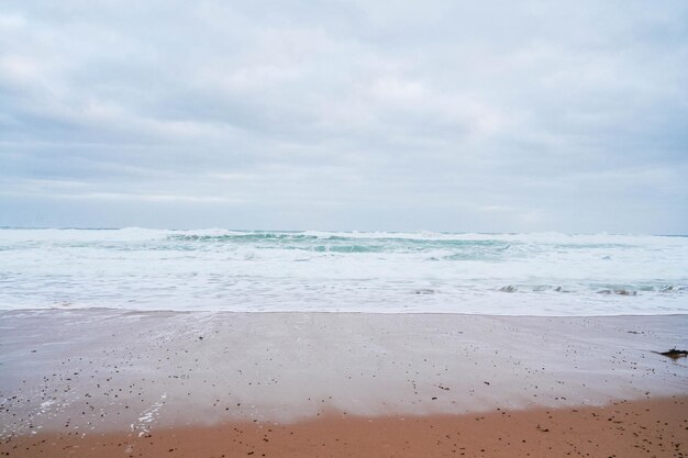 Sandy beach with big waves at the Great Ocean Road Australia