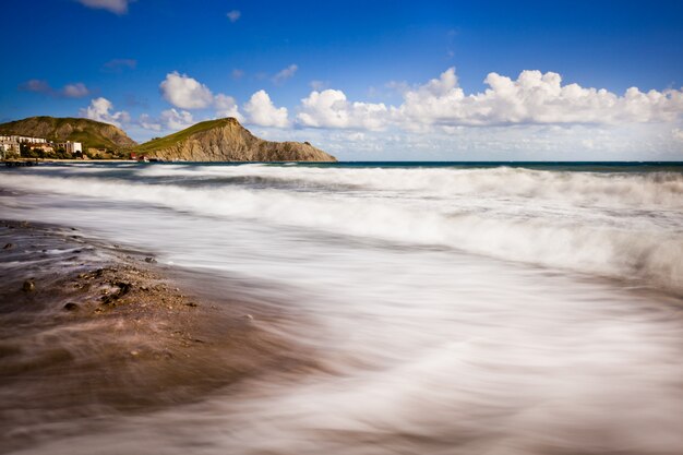 Sandy beach with mountains and cloudy sky