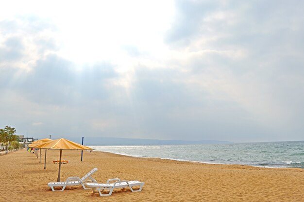 Sandy beach with umbrellas, deck chairs. without people