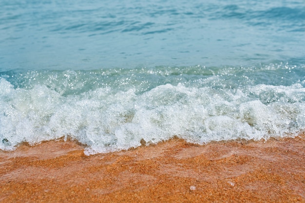 Sandy beach with waves from the sea.