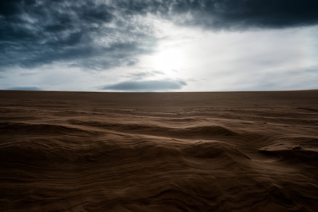 Sandy dunes with dark cloudy sky