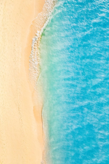 Песчаный берег с бирюзово-зеленой морской водой. Небольшие волны на пляже. Красивый тропический рай
