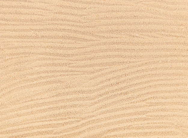 Sandy waves texture background, beach top view.