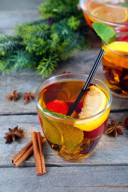 Sangria in bowl and glasses with Christmas decoration on wooden table close up