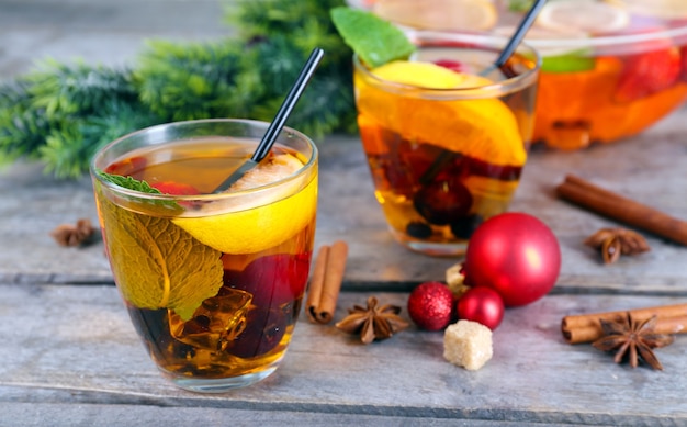 Sangria in kom en glazen met kerstversiering op houten tafel close-up