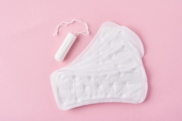 Sanitary pad and menstrual tampon on a pink background