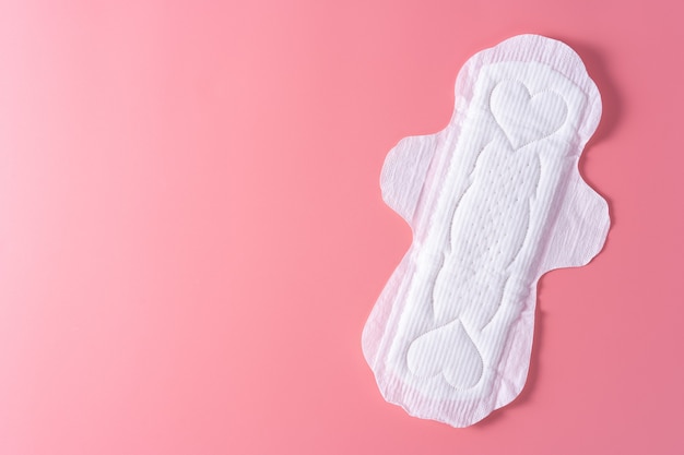 Photo sanitary pad, sanitary napkin on pink background. menstruation, feminine hygiene, top view.