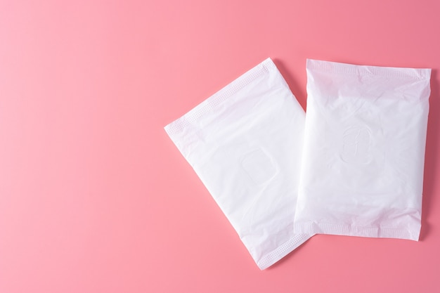 Photo sanitary pad, sanitary napkin on pink background. menstruation, feminine hygiene, top view.