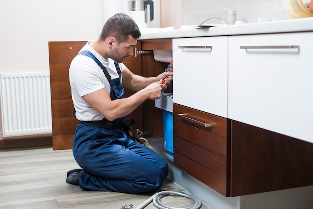 Foto tecnico sanitario che lavora alla cucina