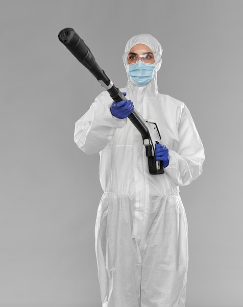 sanitation worker in hazmat with pressure washer
