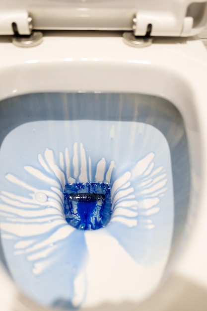 Sanitizing the toilet bowl with blue gel