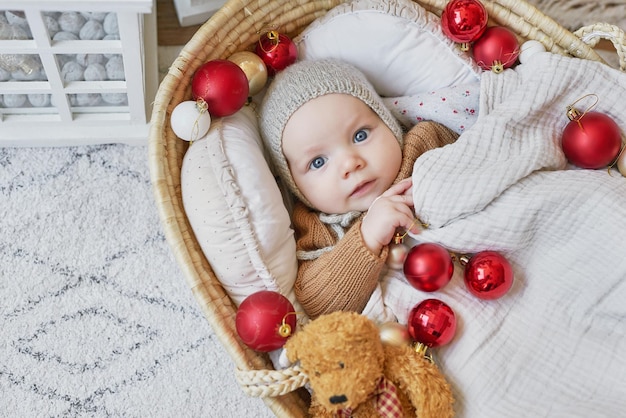 Santa baby Beautiful child lies in cradle near Christmas tree Merry christmas and happy new year