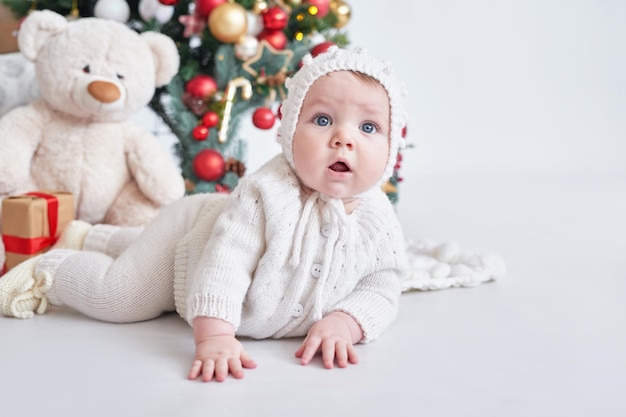 산타 아기 크리스마스 트리 배경 니트 양복에 행복 한 새 해 아이