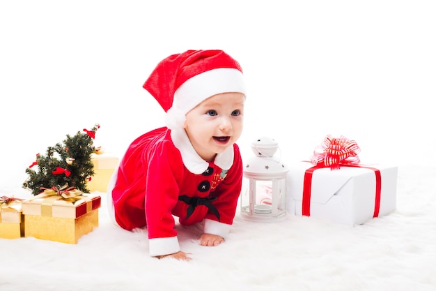 Santa baby girl with gift box and christmas decorations on a fur