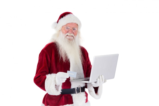 Santa betaalt met een creditcard op een laptop