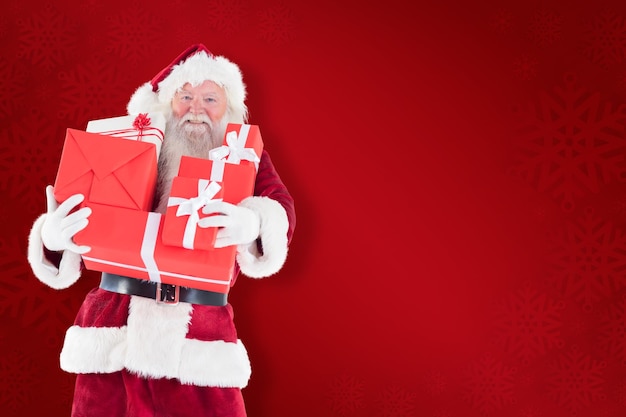 Photo santa carries a few presents against red background