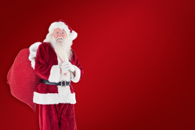 Santa carries his red bag against red background