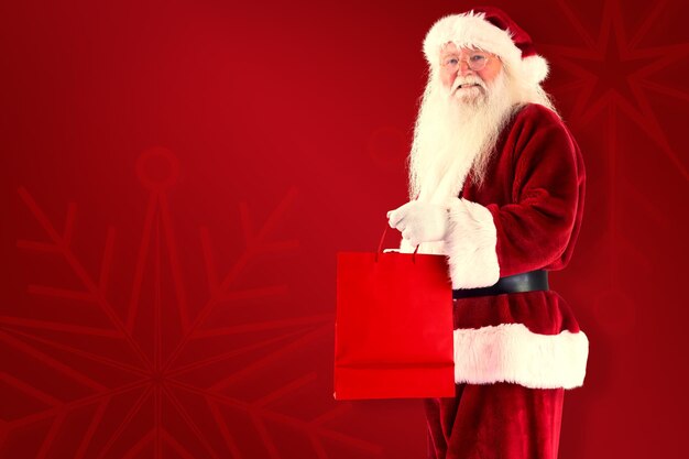 Santa carries red gift bag against red background