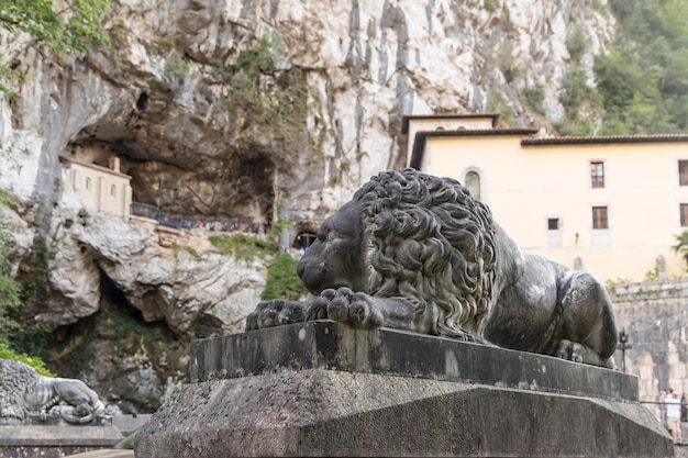 Photo santa cave of covadonga with statue of lion prostrate in the foreground asturias picos de europa spain