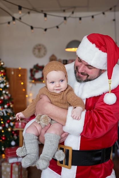 Santa Claus and baby on background of Christmas tree Happy new year and merry christmas Christmas family