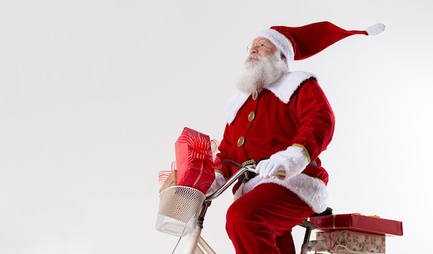 Santa Claus on bicycle delivering Christmas gifts.