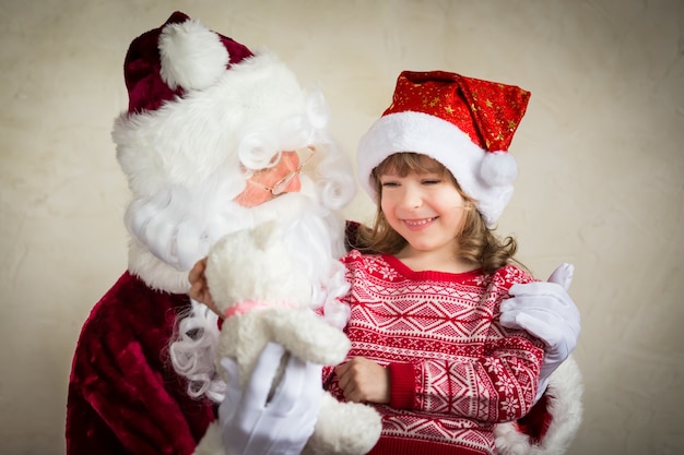 サンタクロースと子供が家にいます。クリスマスプレゼント。家族の休日の概念